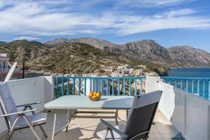 a table and chairs on a balcony with a view of the ocean at Hotel Glaros Karpathos in Karpathos