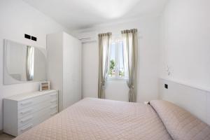 a white bedroom with a bed and a mirror at Antichi Ricordi - Il Sole in Marina di Andora +25 photos