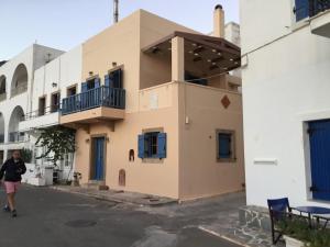a woman walks in front of a building at Emma's maisonette house by Kapsali beach in Kapsali
