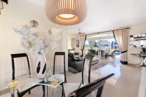 a living room with a glass table with a vase of flowers at Villa Romano in Adeje