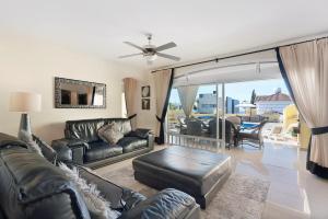 a living room with leather furniture and a balcony at Villa Romano in Adeje