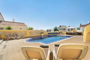 a patio with chairs and a swimming pool at Villa Romano in Adeje