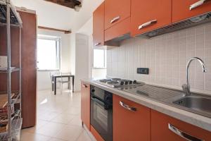 a kitchen with orange cabinets and a stove and a sink at Serra Monolocale in Bonassola