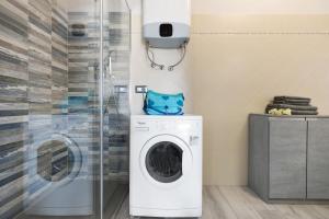 a washing machine in a bathroom with a shower at Giaely in Borghetto Santo Spirito