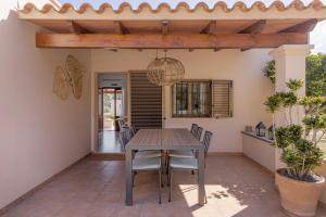 a patio with a wooden table and chairs at Ca N'Alicia Des Bosch in Illes Balears
