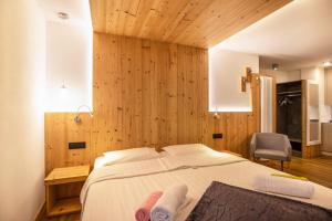 a bedroom with a large bed with wooden walls at Chalet Osmar Suite 2 in Campitello di Fassa