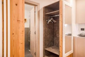 a kitchen with a closet with a wooden door at Chalet Osmar Suite 2 in Campitello di Fassa +23 photos