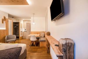 a room with a bed and a television on a wall at Chalet Osmar Suite 2 in Campitello di Fassa