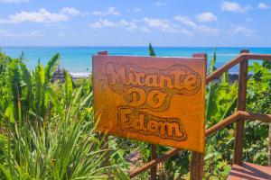 a sign on a fence with the ocean in the background at Casa Edom - Maceió in Maceió