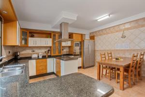 a kitchen with wooden cabinets and a wooden table with a dining room at Corralejo Ian’s Dreams in Corralejo