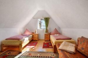 a attic room with two beds and a window at Ferienwohnung Sila 3 in Weinstadt