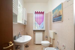 a bathroom with a sink and a toilet and a window at Il Frutteto 48 in Ortovero +11 photos