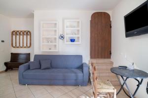 a living room with a blue couch and a table at Il Frutteto 48 in Ortovero