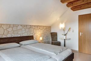 a bedroom with a bed with a stone wall at Ferienwohnung Heilsbergblick in Hilzingen