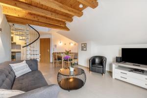 a living room with a couch and a tv and a table at Ferienwohnung Heilsbergblick in Hilzingen