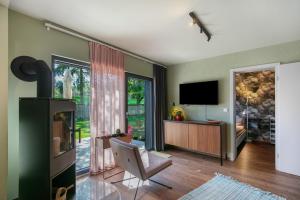 a living room with a flat screen tv and a chair at Ferienwohnung 250m zum Grimnitzsee in Joachimsthal