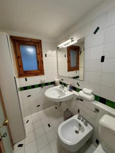 a white bathroom with a sink and a toilet at Apartments San Biagio in Vicenza +27 photos