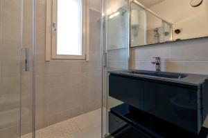 a bathroom with a sink and a glass shower at Ad occhi aperti - Castelsardo in Castelsardo +14 photos