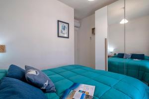 a living room with a blue couch and a bed at Ad occhi aperti - Castelsardo in Castelsardo