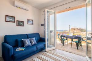 a living room with a blue couch and a table at Ad occhi aperti - Castelsardo in Castelsardo
