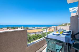 a table on a balcony with a view of the ocean at Ad occhi aperti - Castelsardo in Castelsardo