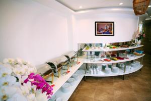 a store with white shelves filled with dishes and flowers at New Space Hotel Airport in Ho Chi Minh City