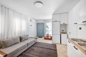 a living room with a couch and a sink at VICE by Apiro Syros in Ermoupoli