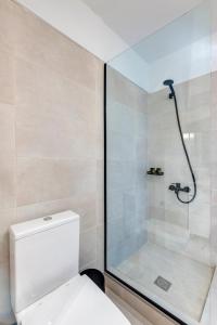 a bathroom with a shower and a white toilet at VICE by Apiro Syros in Ermoupoli