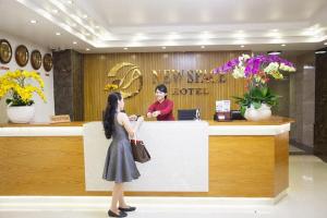 a woman standing at the counter of a new star hotel at New Space Hotel Airport in Ho Chi Minh City