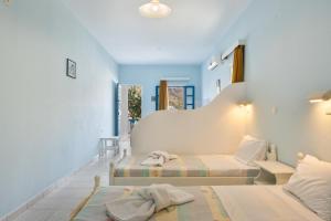 two beds in a room with blue walls at Hotel Glaros Karpathos in Karpathos