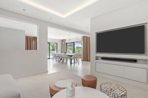 a living room with a flat screen tv on a wall at Villa Belenos Piscine vue mer in Roquebrune-sur-Argens