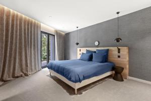 a bedroom with a blue bed and a large window at Villa Belenos Piscine vue mer in Roquebrune-sur-Argens +33 photos