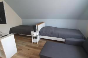 ein Schlafzimmer mit zwei Betten, einem Schreibtisch und einem Fernseher in der Unterkunft Bei Heike in Zetel