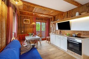 a living room with a blue couch and a kitchen at Galtinerhof in Rodengo