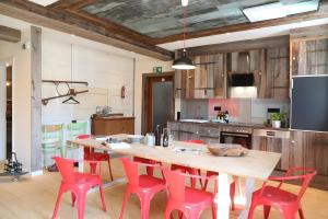 a kitchen with a wooden table and red chairs at Ferienwohnungen beim Weilerbauer in Gerstetten