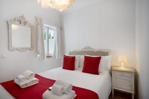 a bedroom with a bed with red and white towels on it at Páteo da Várzea 4 in Colares
