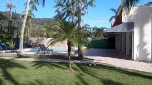 a palm tree in the yard of a house at Hotel Lagoinha in Ubatuba