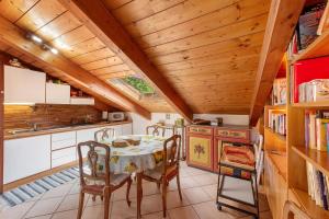 a kitchen with a table and chairs and a wooden ceiling at La Liguria tra gli Ulivi 2 in Varazze