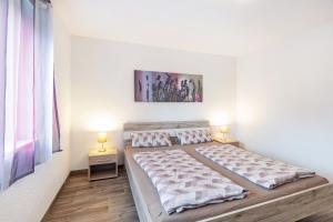 a bedroom with two beds and two lamps on tables at Ferienwohnung Sonnenberg in Degerfelden
