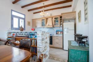 a kitchen with a table and a refrigerator at Orkos View House in Naxos Chora
