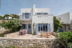 a house with chairs and tables in front of it at Orkos View House in Naxos Chora