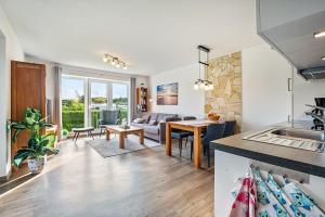 a kitchen and living room with a couch and a table at Kleine Auszeit - Hohe Lith in Cuxhaven