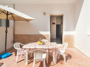 a table and chairs with a table and an umbrella at Villa Tetta sul mare in Torre Lapillo +13 photos