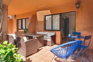 an outdoor patio with chairs and a table and a table at Oasis Duna_Sun Fun Pool in Corralejo