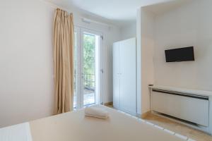 a white room with a television and a window at Melus Maris in Syracuse