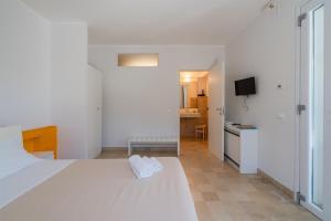 a white bedroom with a white bed and a kitchen at Melus Maris in Syracuse +32 photos