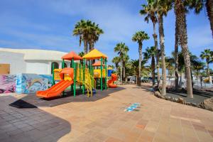 a playground with slides and palm trees in a park at Oasis Duna_Sun Fun Pool in Corralejo