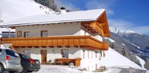 a snow covered building with a car parked in front of it at Niederkoflhof Durreck in Cadipietra