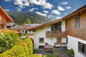 a house with a patio and a balcony with a table at Ferienwohnung Gallist in Oberammergau