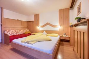 a bedroom with a bed and a couch at Niederkoflhof Durreck in Cadipietra